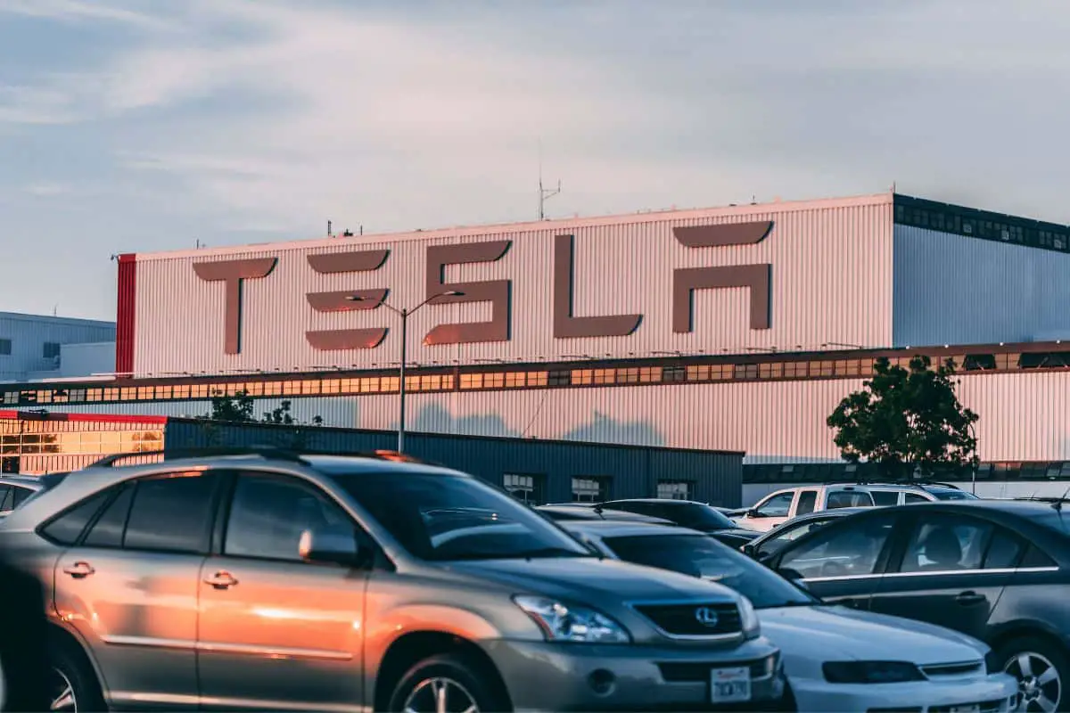 photo of cars parked in the parking lot of a tesla car plant