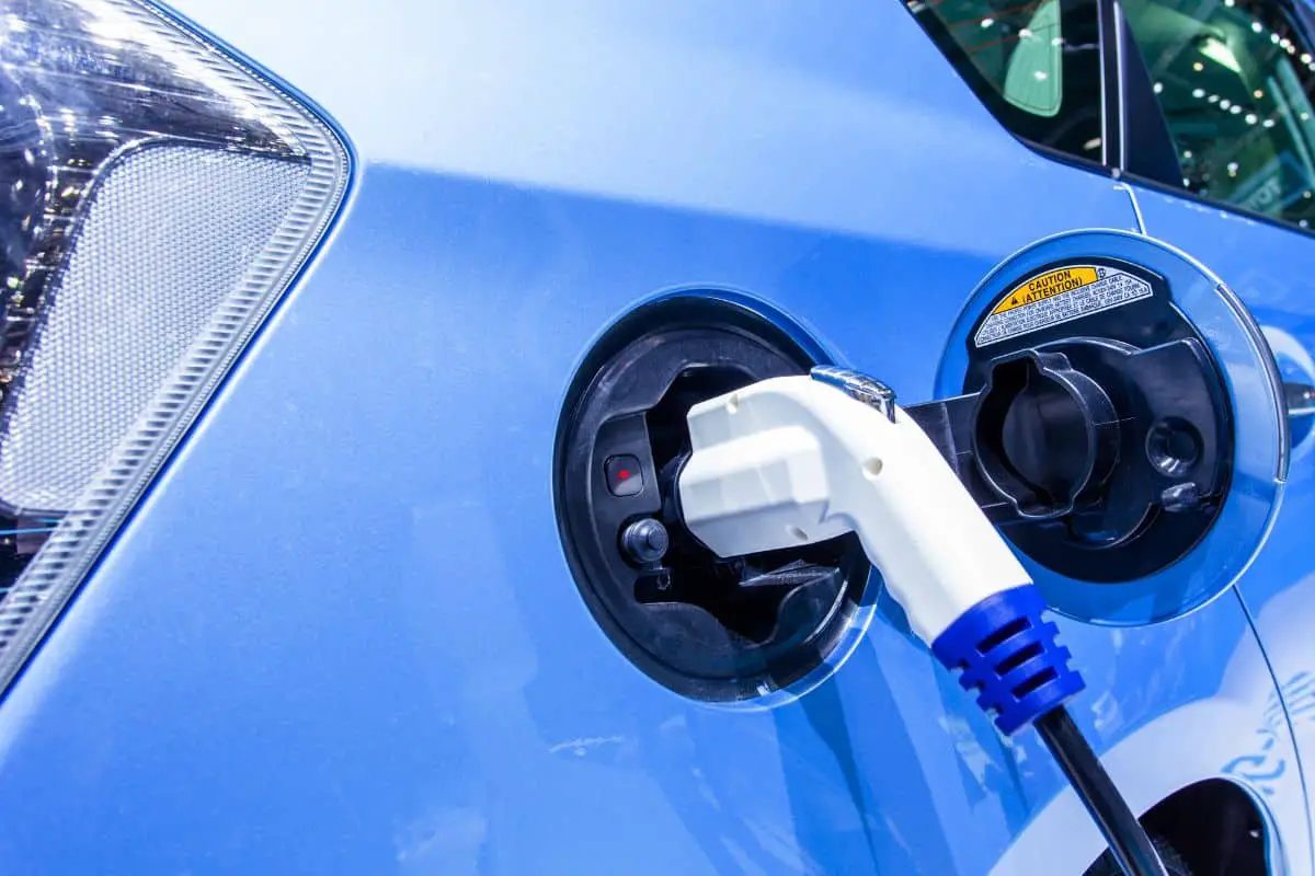 a hybrid electric car being charged via a charger and charging plug