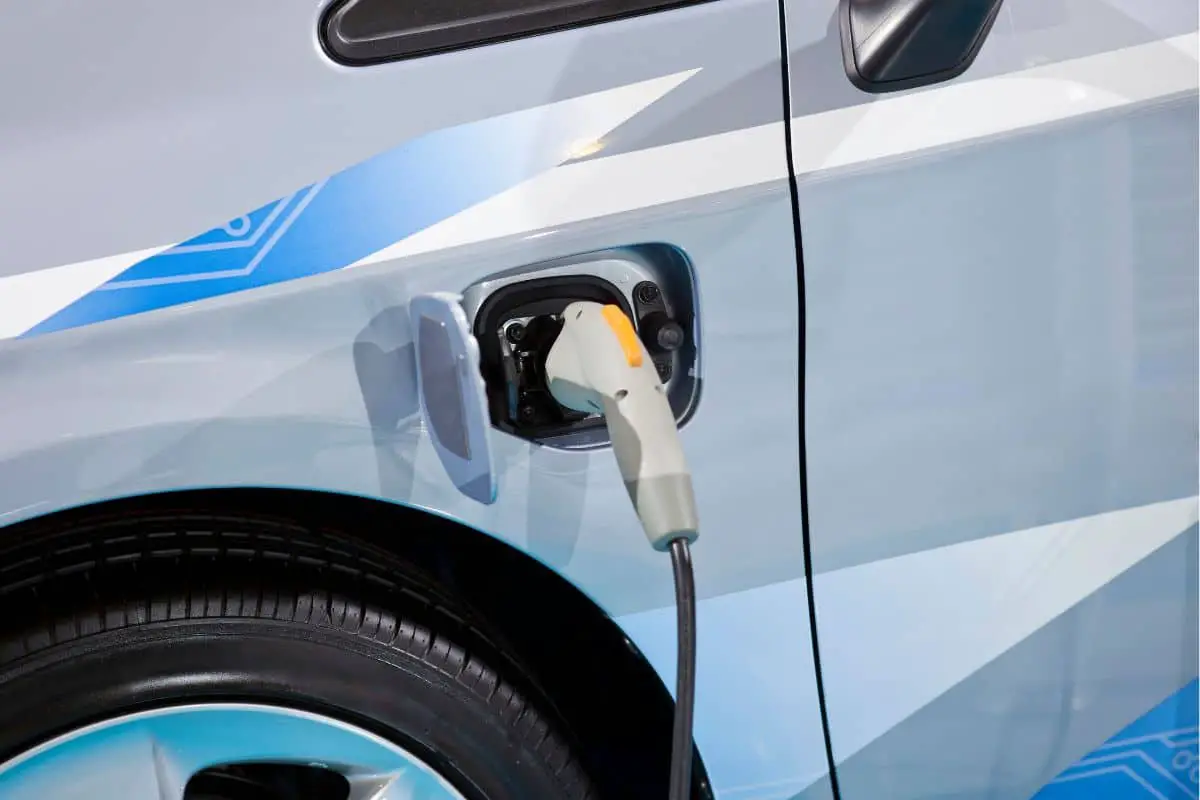 a hybrid electric vehicle car connected to a charger via a charging plug which is inserted into the car's plug socket