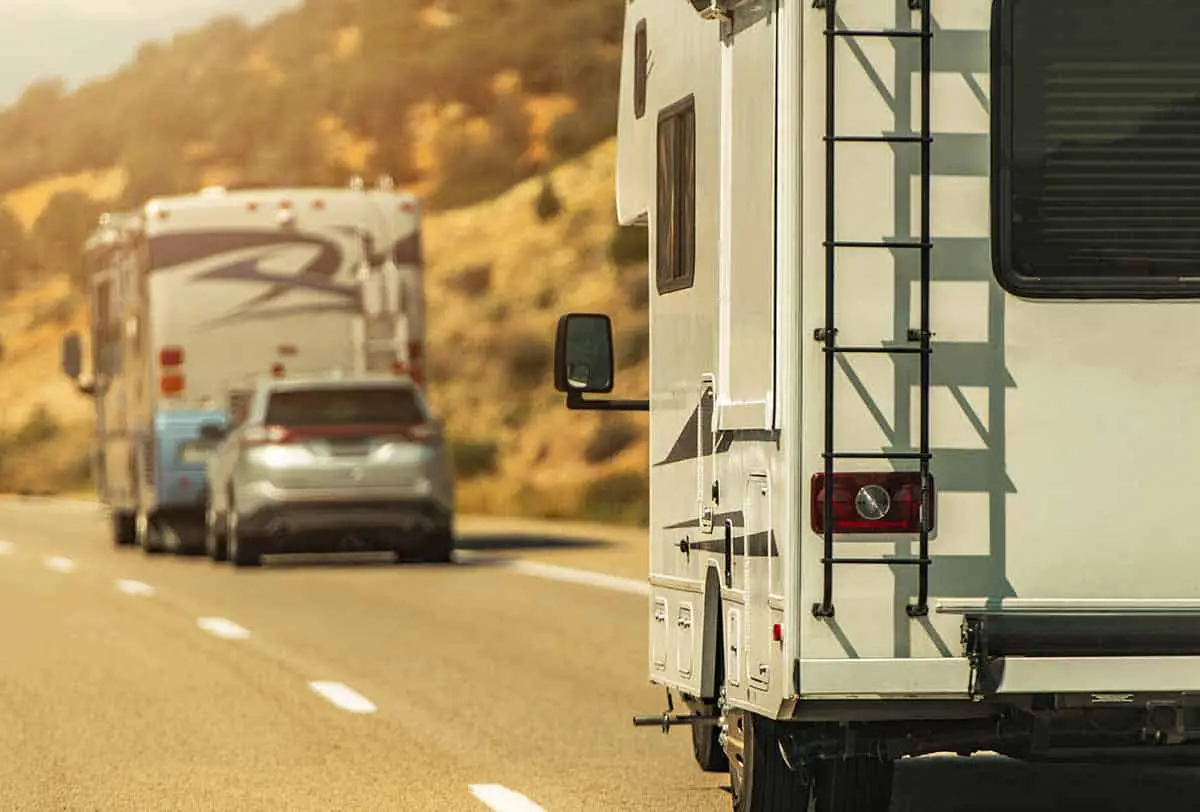 camper van and diesel pusher motorhome flat tow on a highway