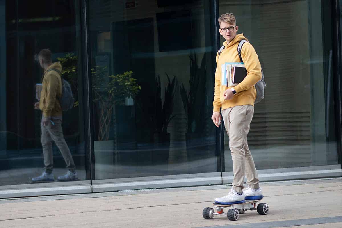 student commuting on electric skateboard