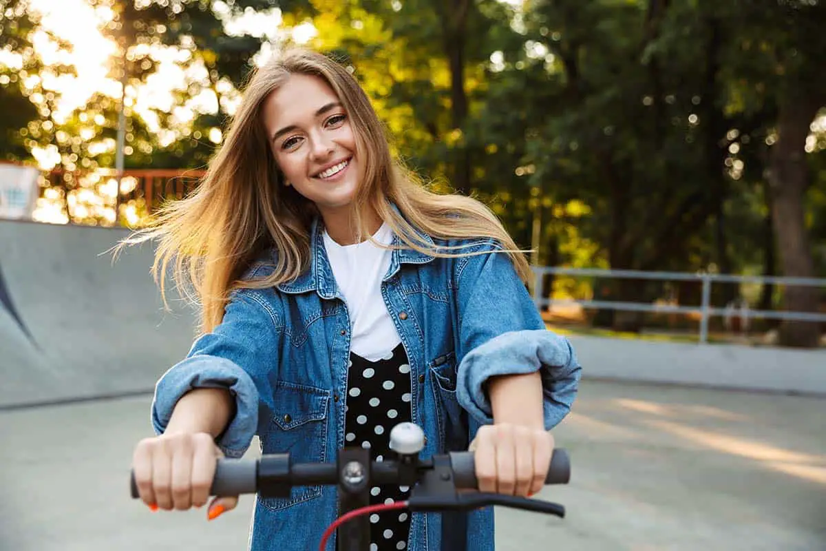 teenage girl having fun on an electric scooter at a skate park