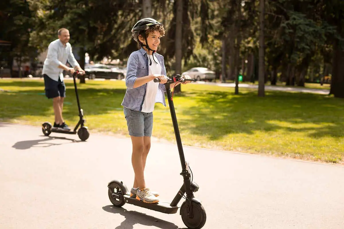 teenager and father skating on electric scooters