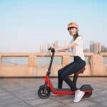 photo-of-a-smiling-attractive-young-woman-riding-on-an-electric-scooter-with-seat