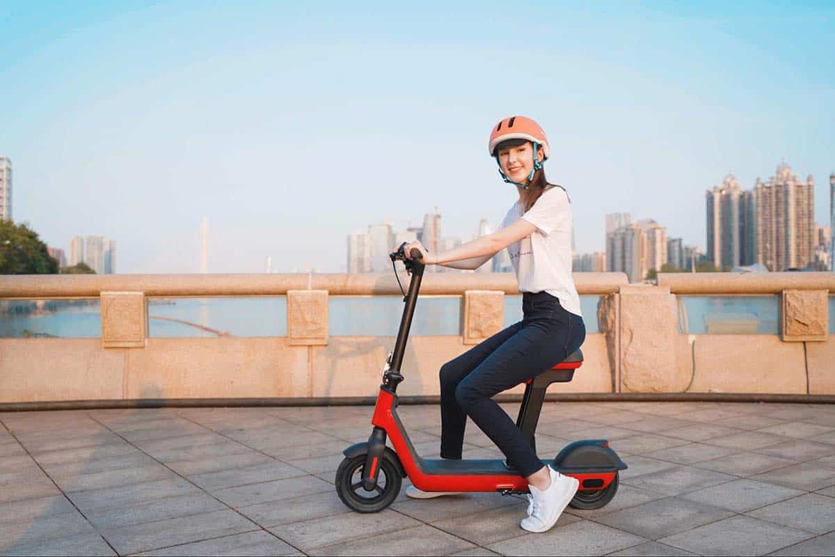 photo-of-a-smiling-attractive-young-woman-riding-on-an-electric-scooter-with-seat