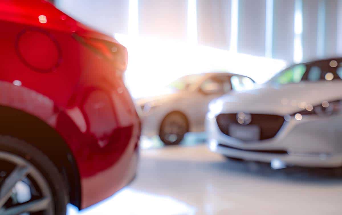 blurred-photo-of-white-and-red-luxury-car-parked-in-showroom