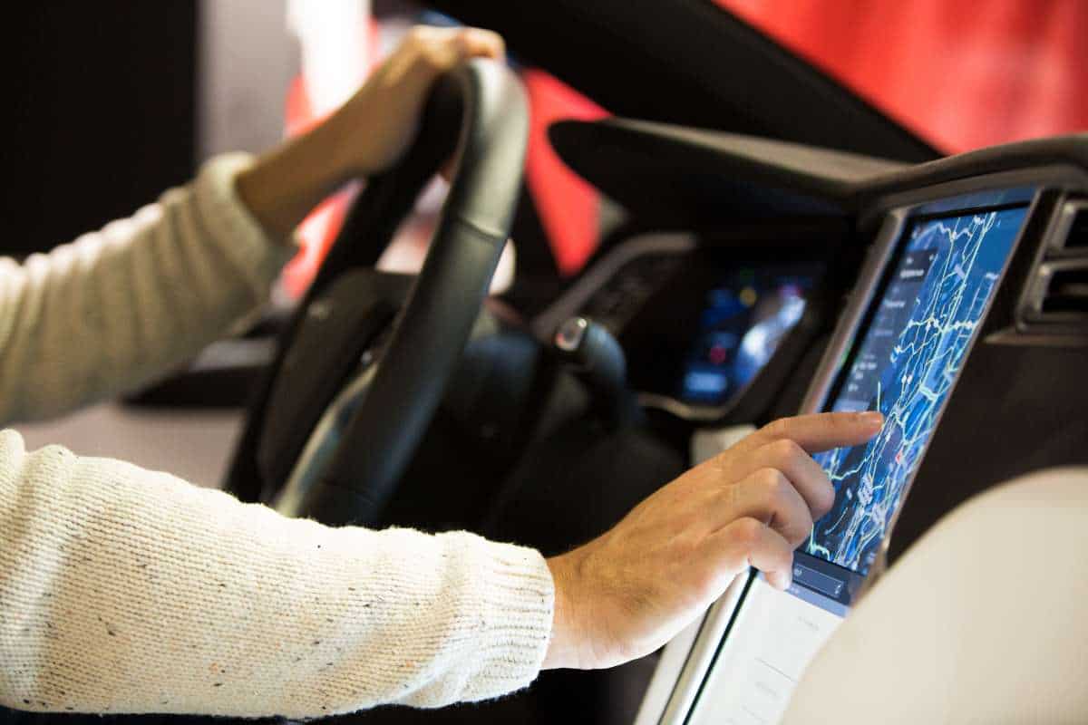 tesla driver and touchscreen display showing map