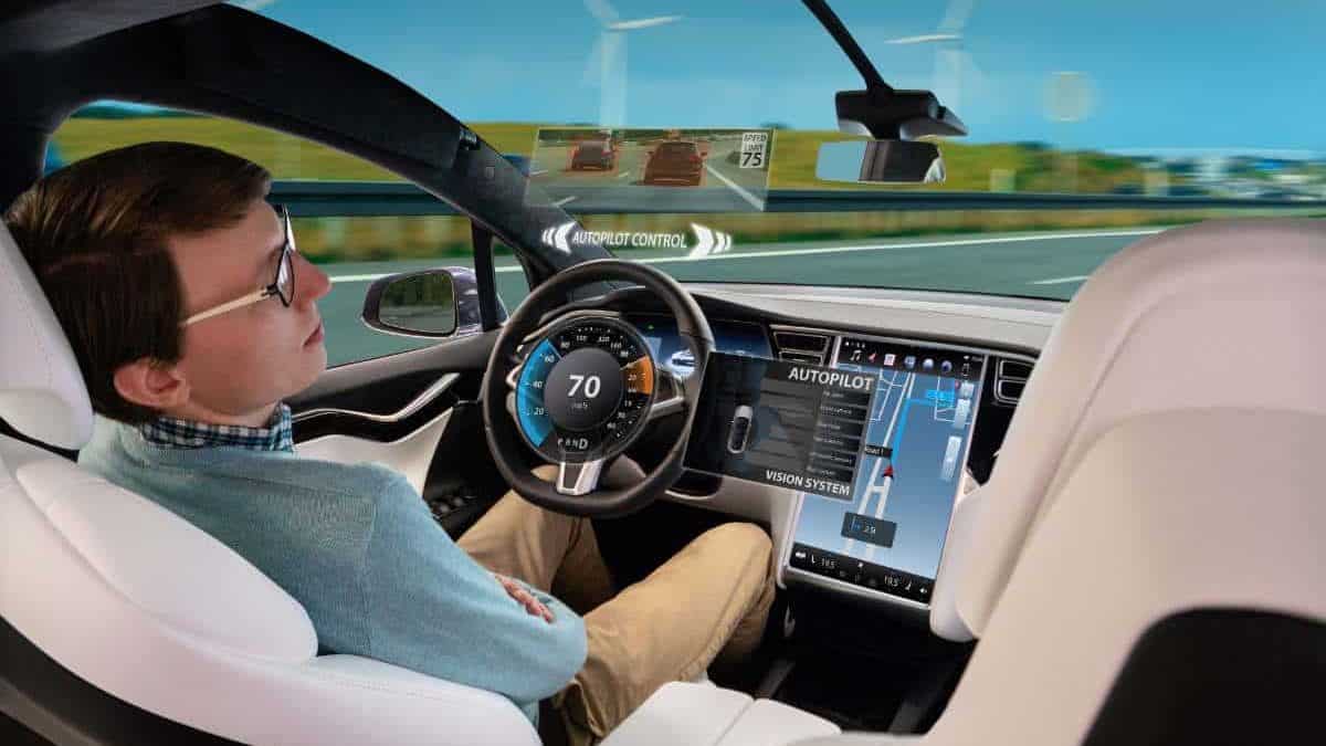 a man sleeping in the driving seat of a self driving tesla in autopilot mode