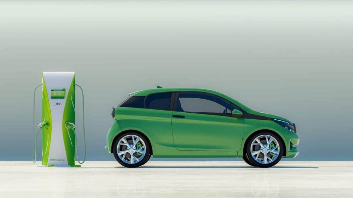 green small electric car parked beside a charging point
