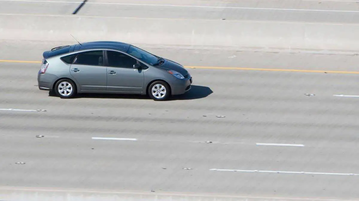 a toyota prius drives on a highway