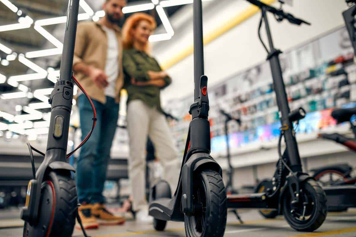 a couple in an electric scooter store choosing an electric scooter to buy