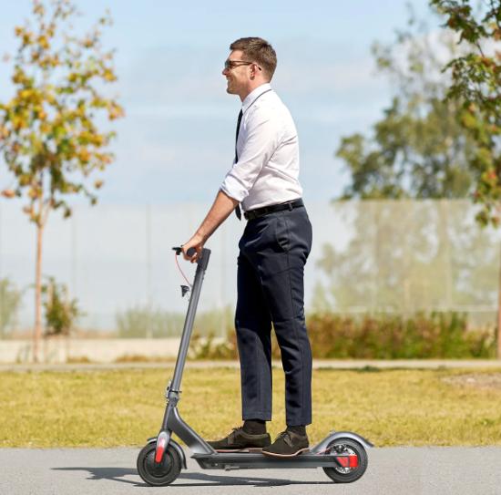 turboant m10 pro electric foot scooter product photo of office worker riding it in a park